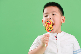 可爱的小男孩拿着棒棒糖图片