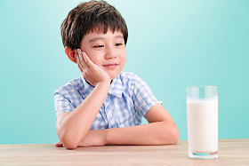 小男孩看着一杯牛奶图片