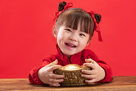 小女孩拿着金元宝过新年照片