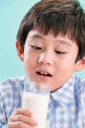 小男孩看着一杯牛奶