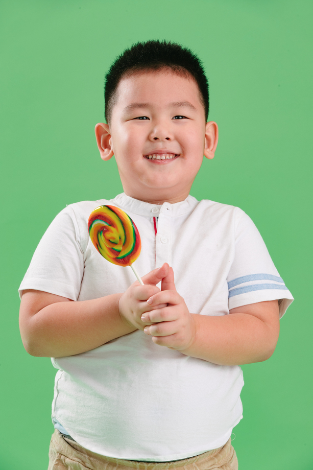 可爱的小男孩拿着棒棒糖图片