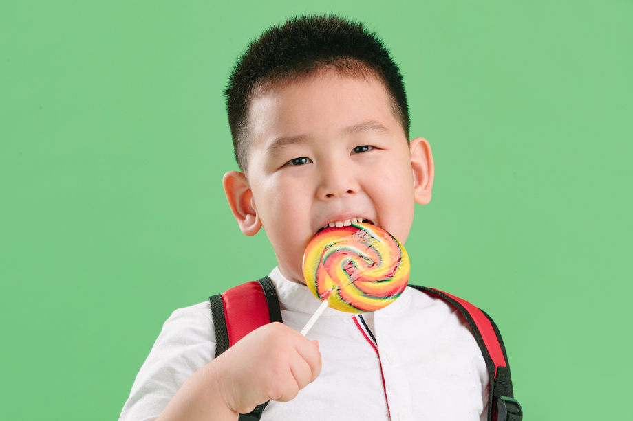 可爱的小男孩拿着棒棒糖照片