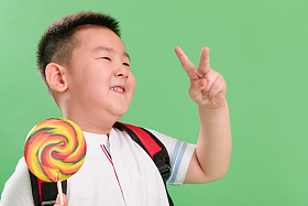 可爱的小男孩拿着棒棒糖图片