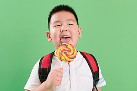 可爱的小男孩拿着棒棒糖照片
