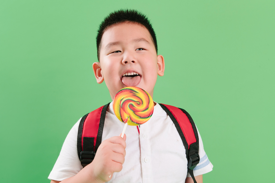 可爱的小男孩拿着棒棒糖照片