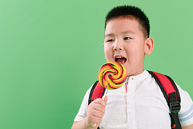 可爱的小男孩拿着棒棒糖图片