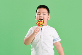 可爱的小男孩拿着棒棒糖图片