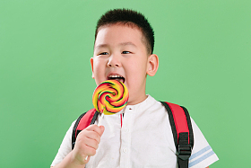 可爱的小男孩拿着棒棒糖图片