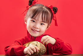 小女孩拿着金元宝过新年