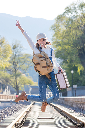 青年女人在铁轨上跳跃照片