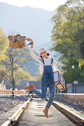 青年女人在铁轨上跳跃