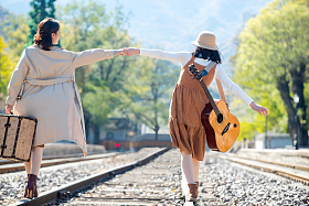 青年闺蜜手牵手走在铁轨上