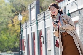 旅行的青年女人拿着照相机图片
