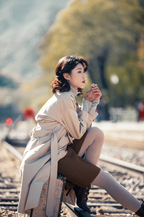 青年女人坐在铁轨上