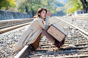 青年女人坐在铁轨上