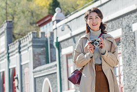 旅行的青年女人拿着照相机图片