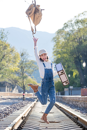 青年女人在铁轨上跳跃