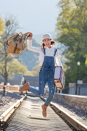 青年女人在铁轨上跳跃