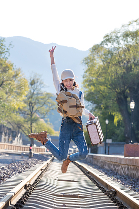 青年女人在铁轨上跳跃