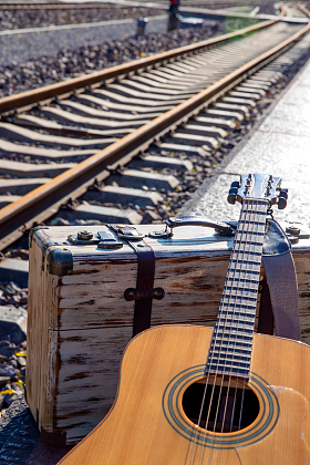 铁轨旁边的吉他和旅行箱