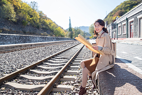 青年女人坐在铁轨旁边