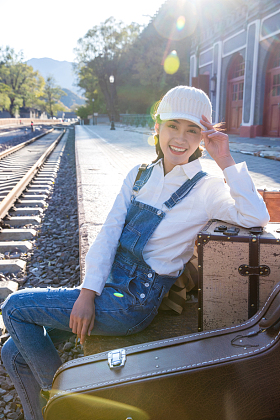 青年女人坐在铁轨旁边