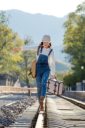 青年女人在铁轨上行走图片