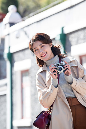 旅行的青年女人拿着照相机图片