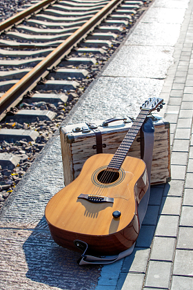 铁轨旁边的吉他和旅行箱图片