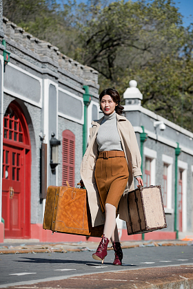青年女人拿着行李箱旅