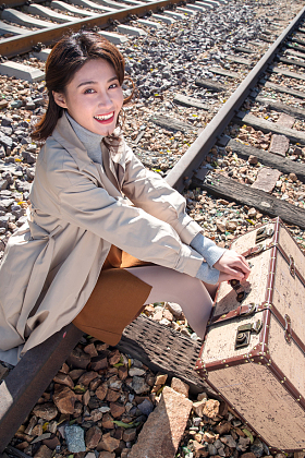 青年女人坐在铁轨上