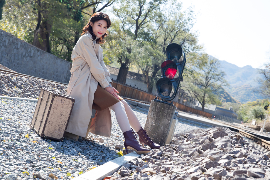 青年女人坐在铁轨旁边