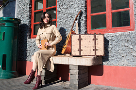 青年女人坐在火车站站台上看书