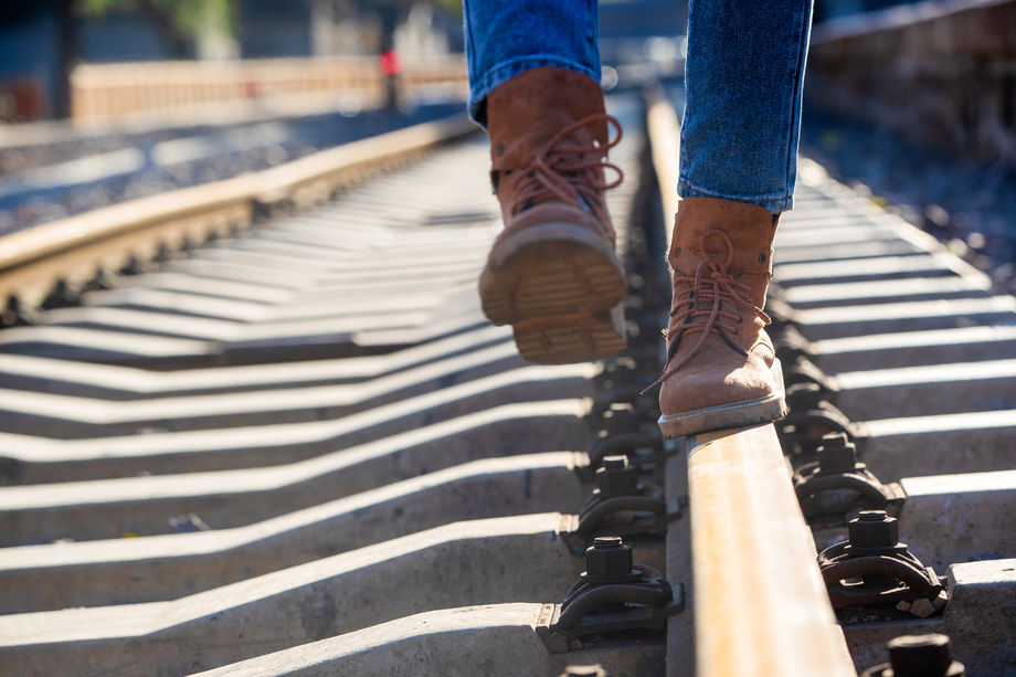 青年女人徒步走在铁轨上 青年女人徒步走在铁轨上