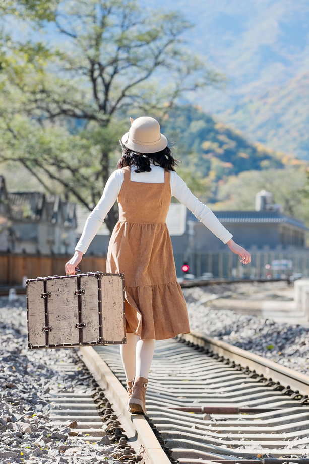 青年女人在铁轨上行走图片