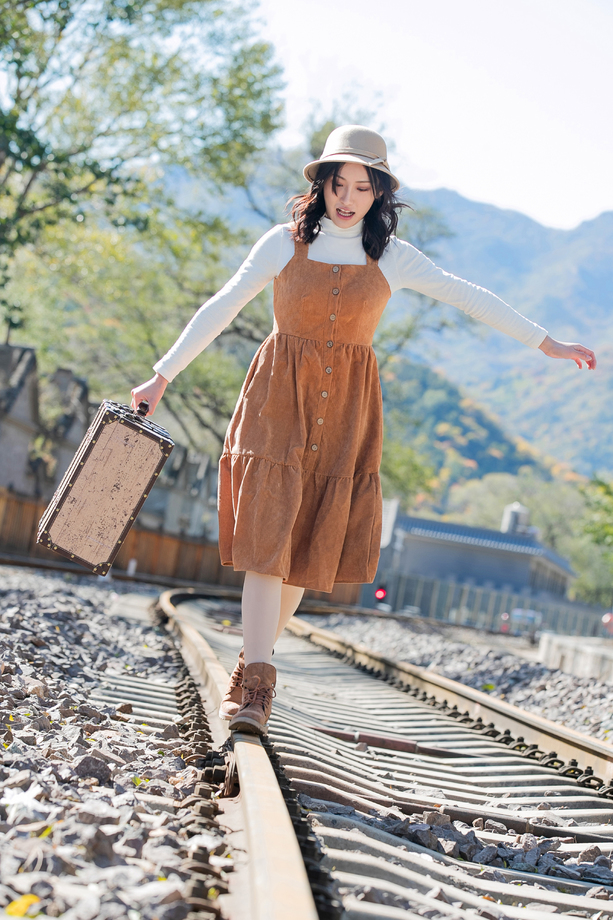 青年女人在铁轨上行走照片