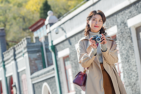 旅行的青年女人拿着照相机图片