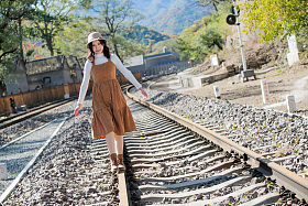 青年女人在铁轨上行走