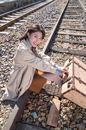 青年女人坐在铁轨上