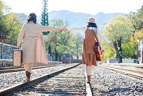 青年闺蜜手牵手走在铁轨上