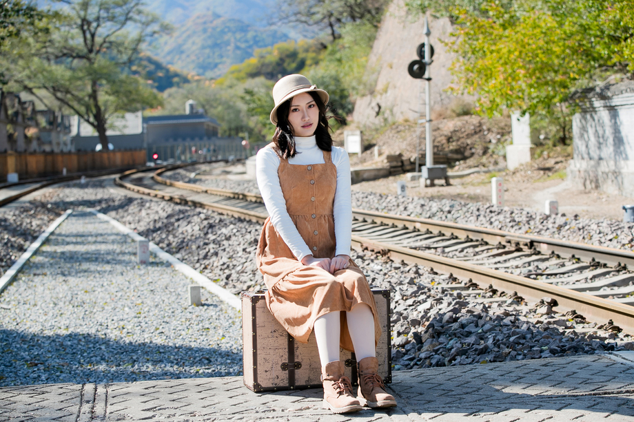 青年女人坐在铁轨上