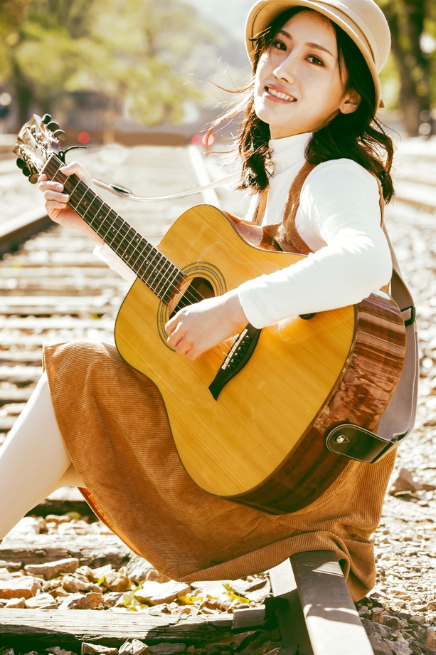 青年女人坐在铁路边弹吉他 青年女人坐在铁路边弹吉他