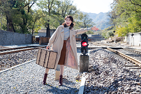 青年女人站在铁轨上