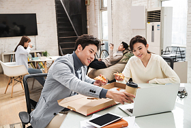 青年商务人士边吃披萨边工作图片