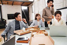 青年商务团队在办公室里用餐照片