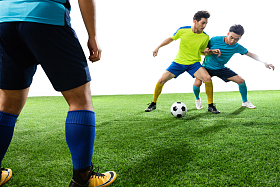 足球运动员在球场上踢球照片