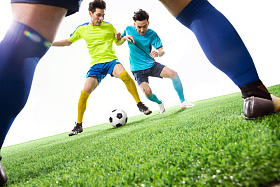 足球运动员在球场上踢球照片