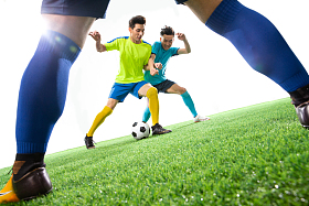 足球运动员在球场上踢球图片