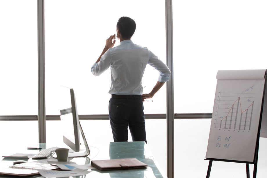 商务男士在窗户前打电话的背影 商务男士在窗户前打电话的背影