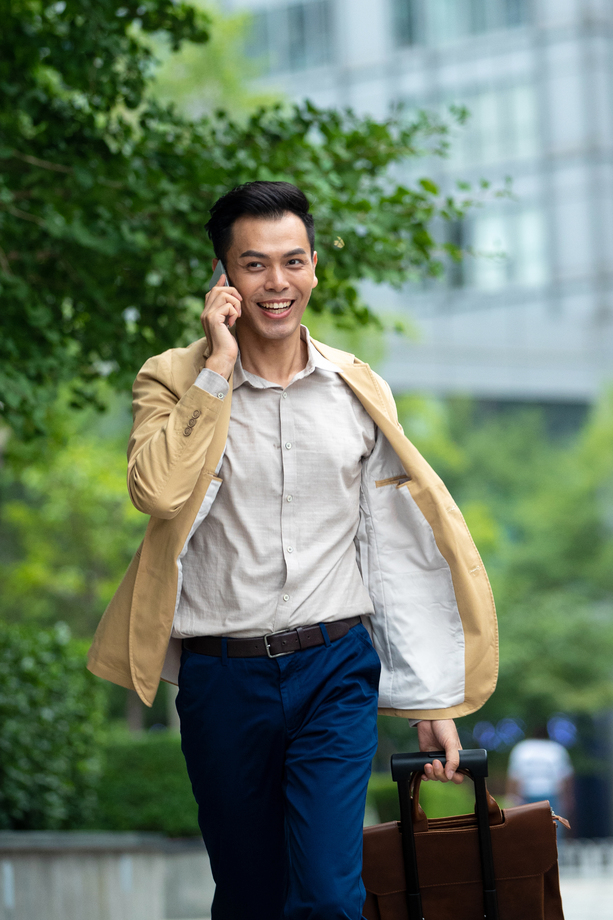 户外拉着行李打电话的商务男子 户外拉着行李打电话的商务男子